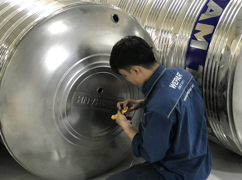 Kỹ thuật viên chuẩn bị và lắp đặt cho hệ thống sản xuất nước đóng bình.